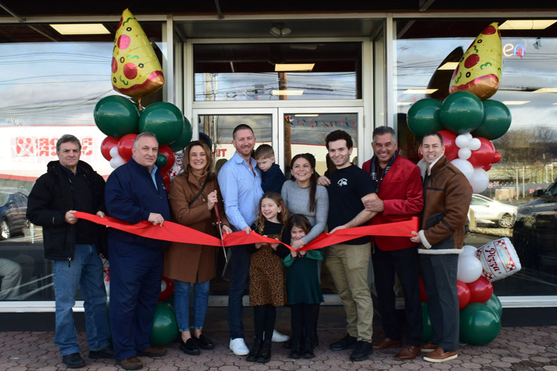 A group of excited people cutting a ribbon to celebrate the grand opening of the new Anthony Francos restaurant in Springfield, NJ.