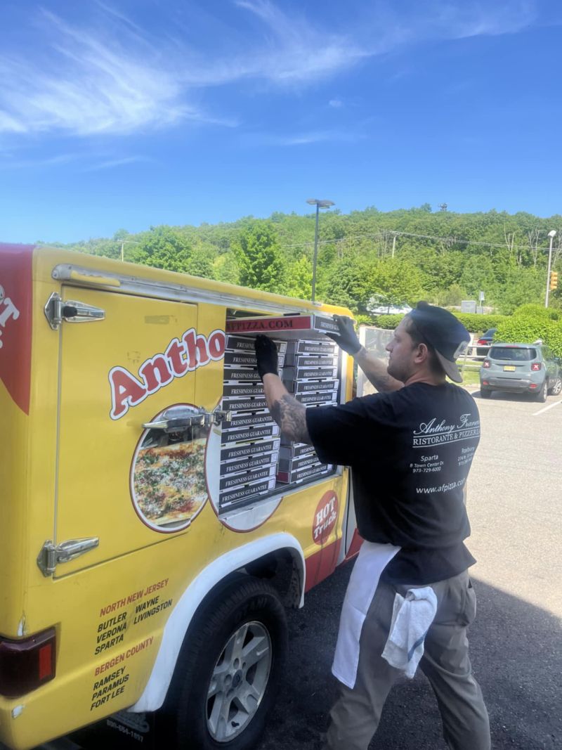 A man loads fresh pizzas into a food truck for delivery at Anthony Francos, located in Sparta, NJ.